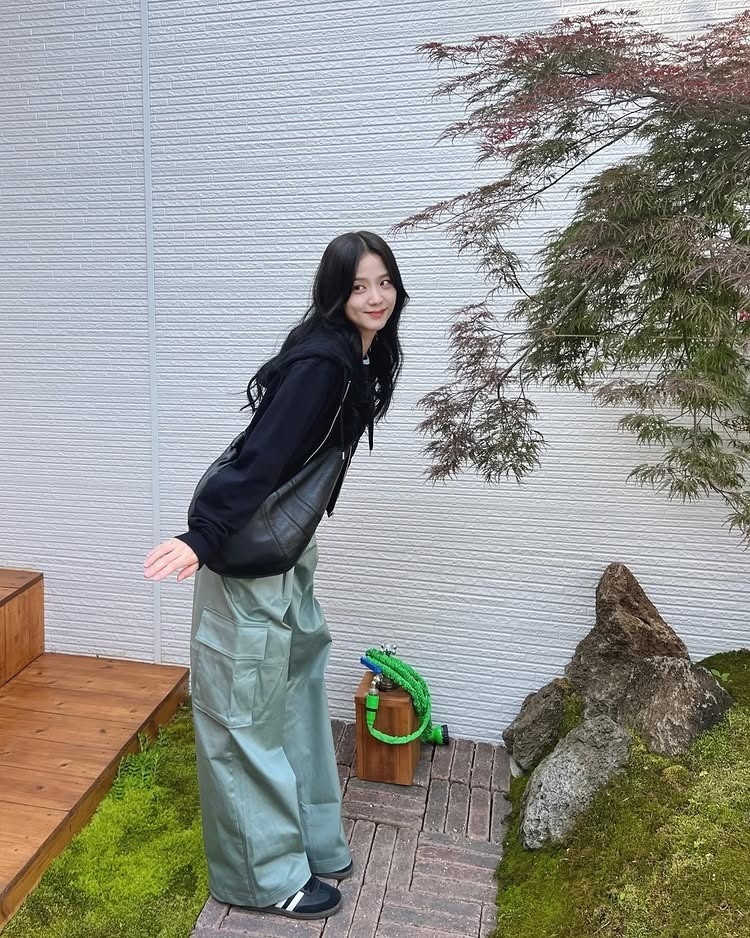 BLACKPINK成員Jisoo的私服穿搭，全黑連帽上衣搭配上薄荷灰綠色工裝褲構成，整體低調卻質感滿分，腳踩德訓鞋的造型多了一點清爽街頭感。