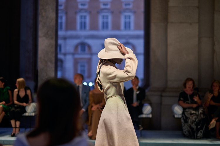 Max Mara2026早春度假系列，模特兒身著經典大衣，手扶著帽子。