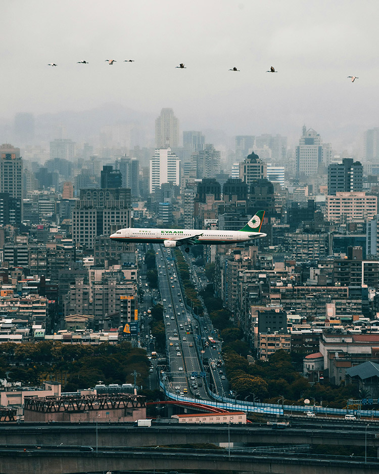 長榮航空的白色機身飛機低空飛過，正準備前往松山機場。