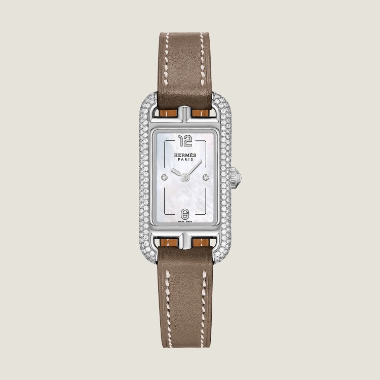 Hermès Nantucket 腕錶,方中帶長的矩形錶殼靈感源自品牌標誌性的「Chaine d'ancre」船錨鍊鏈,這款29毫米的小型精鋼腕錶,以186顆鑽石環繞輪廓,彷彿為時間點上了光暈。