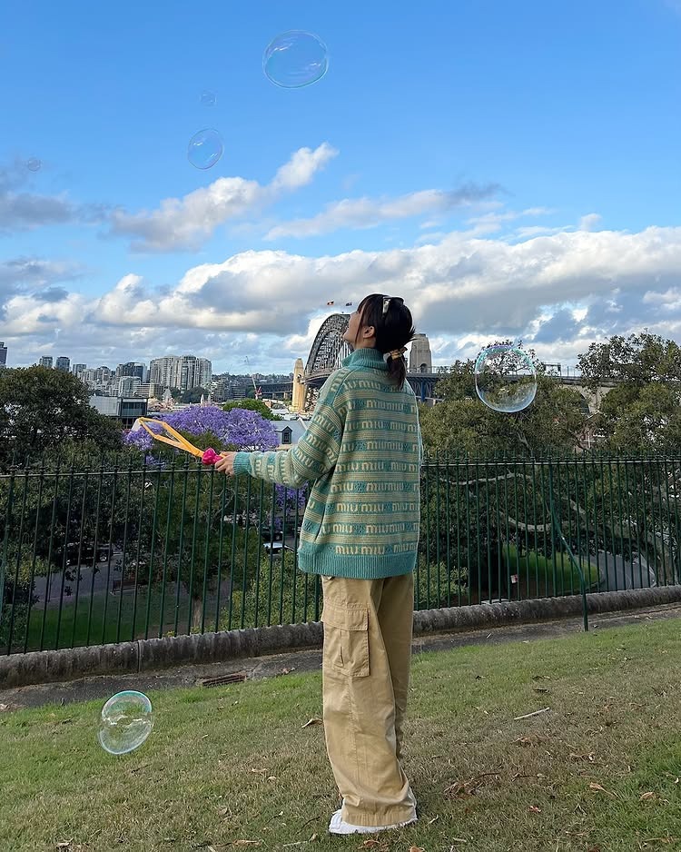 這套私服Look中，Minnie選擇以Miu Miu 的薄荷綠針織開襟毛衣搭配卡其工裝褲，混合了學院感與街頭感，視覺溫柔又不失個性